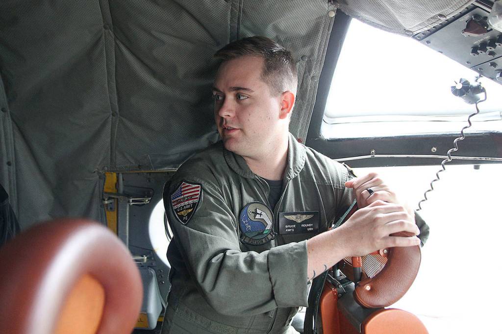 Photo by Laura Guido/Whidbey News-Times                                Petty Officer Second Class Bruce Roundy of Patrol Squadron 69 answers questions from inside the P-3C Orion during the base open house Saturday.