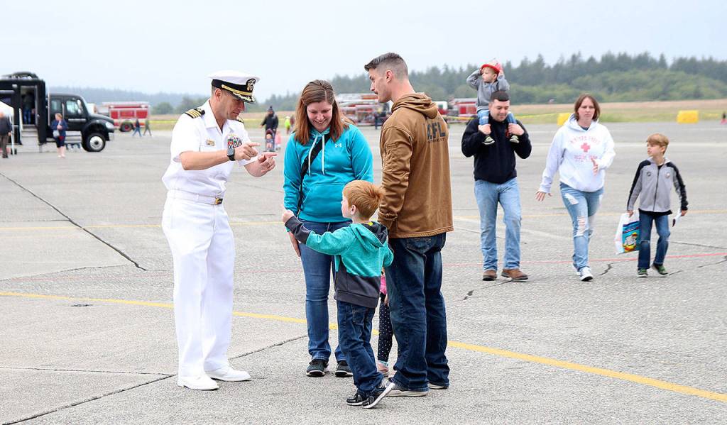 Photo by Laura Guido/Whidbey News-Times                                Base commanding officer Capt. Matt Arny talks to 4-year-old Artcher Fain with his parents Keebe and Jerry Fain at the base Saturday.