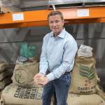 Whidbey Coffee owner Dan Ollis holds a handful of green coffee beans that will be roasted at the companys facility in Mukilteo. (Photos by Jessie Stensland / Whidbey News-Times)