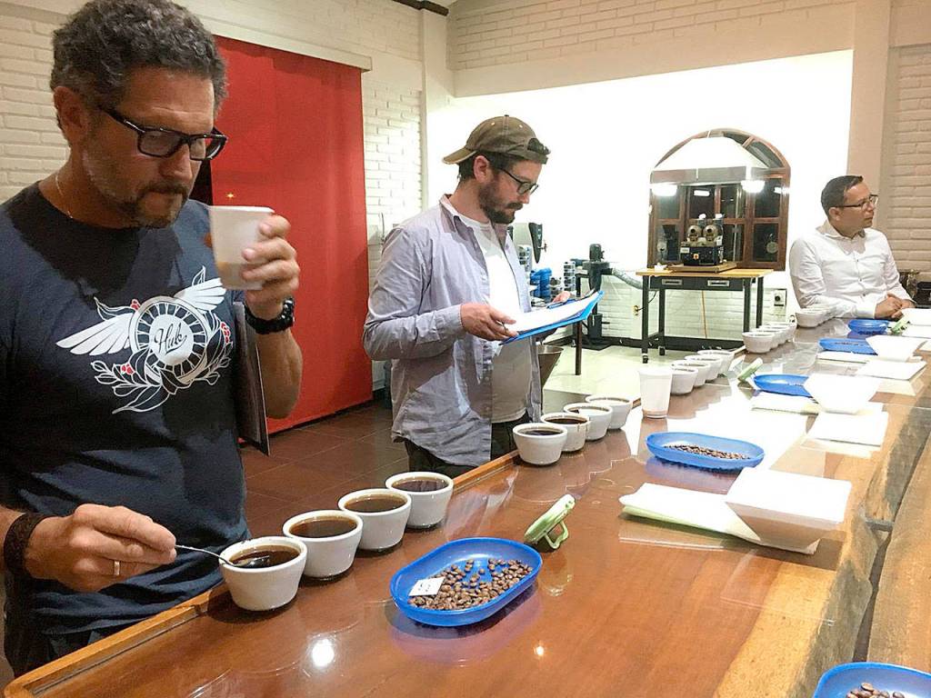 Head raoster Dennis Peseau, in the middle, tastes coffee during a recent trip to Nicaragua. (Photo submitted)