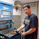 Joe Hilton, a welding instructor for the apprenticeship program, shows the machine that combines virtual reality with reality to teach welding skills. (Photo by Jessie Stensland / Whidbey News Group)