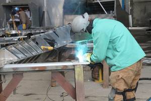 A welder does work on a high-speed passenger ferry that Nichols Brothers is building for Kitsap Transit. (Photo by Jessie Stensland / Whidbey News-Times)