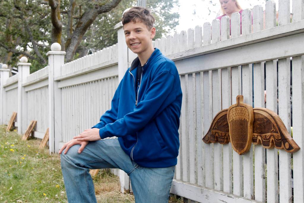 HomeConnection student Jacob Swanson installed the first plaque at the park. Other students and Salty Dog Woodworks installed the remaining pieces of art along the fence.                                (Photo by Maria Matson/Whidbey News-Times)