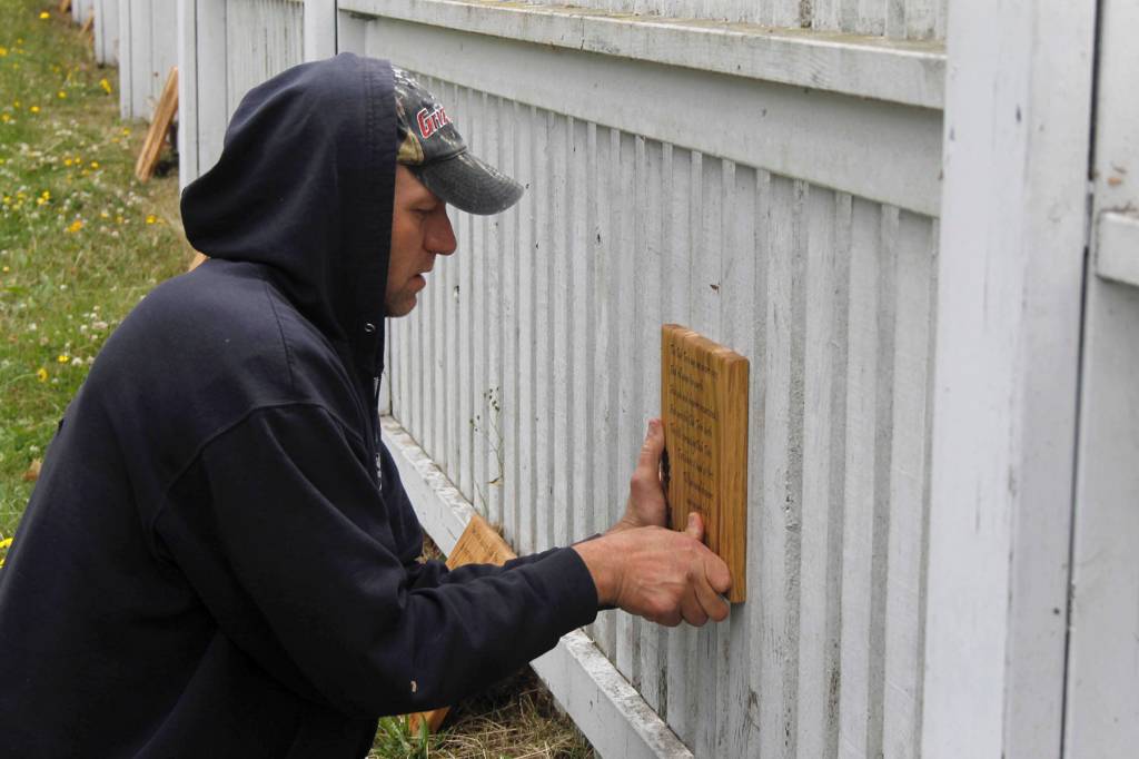 Mark Lugo of Salty Dog Woodworks installs one of the pieces of art.                                (Photo by Maria Matson/Whidbey News-Times)