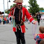 Rob Boyle of the Oak Harbor Yacht Club Buccaneers hands out beads to 3-year-old Finnigan Reilly, who was a fan of the pirate-themed parade float that made loud booms.