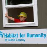 Skyler Stephen waves to the crowd in the Habitat for Humanity of Island County parade float. He is the grandson of a homebuyer.