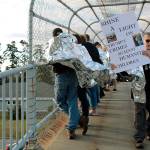 Marcia Comer of Coupeville walks along the overpass. She said President Trumps policies and actions have resulted in child abuse and came to the protests on Friday to take action.
