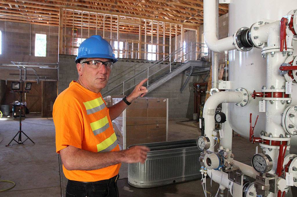 Utility Superintendent Joe Grogan explains how the new granular activated carbon filtration system works. It has been filtering Coupevilles water for about a week. Photo by Laura Guido/Whidbey News-Times