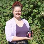 Mercedes Monarch, production associate at Whidbey Island Distillery, holds a bottle of the companys Community Batch of blackberry liqueur. Its made using donated berries and $2 from every bottle sale go toward local nonprofits. The distillery is currently accepting blackberries for next years batch and will donate money for every pound collected. Photo by Laura Guido/Whidbey News Group