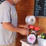 Stephen Williams weighs out some fresh-picked tomatoes at Foxtail Farm stand
