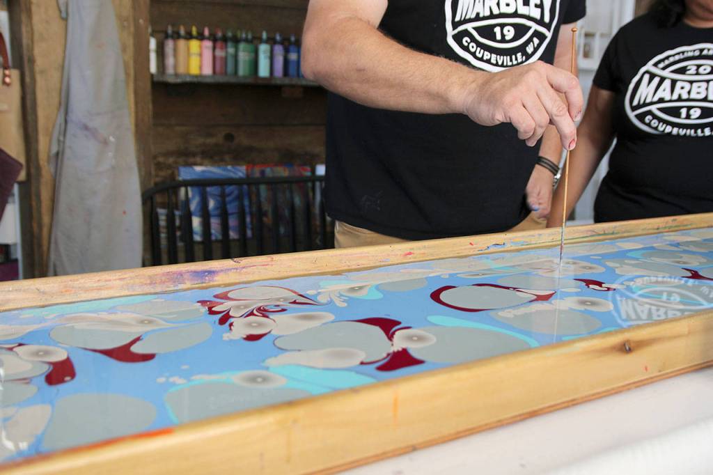 Ed Hodson and Joan Samson demonstrate the water marbling process.