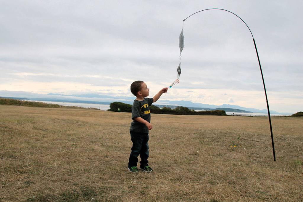 Two-year-old Alakai Dickerson of Issaquah admires an item at the ground kite display set up at the Fort Casey display on Saturday Sept. 7. Whidbey Island Kite Fliers set up the display for fun, capturing the attention of the young visitor.