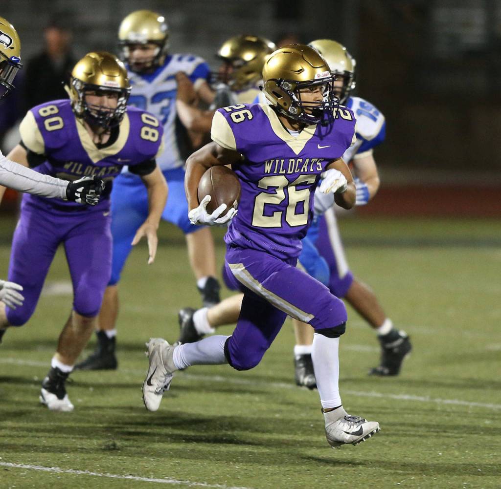 Brenden Andersen (26) looks for yardage after intercepting a pass.(Photo by John Fisken)