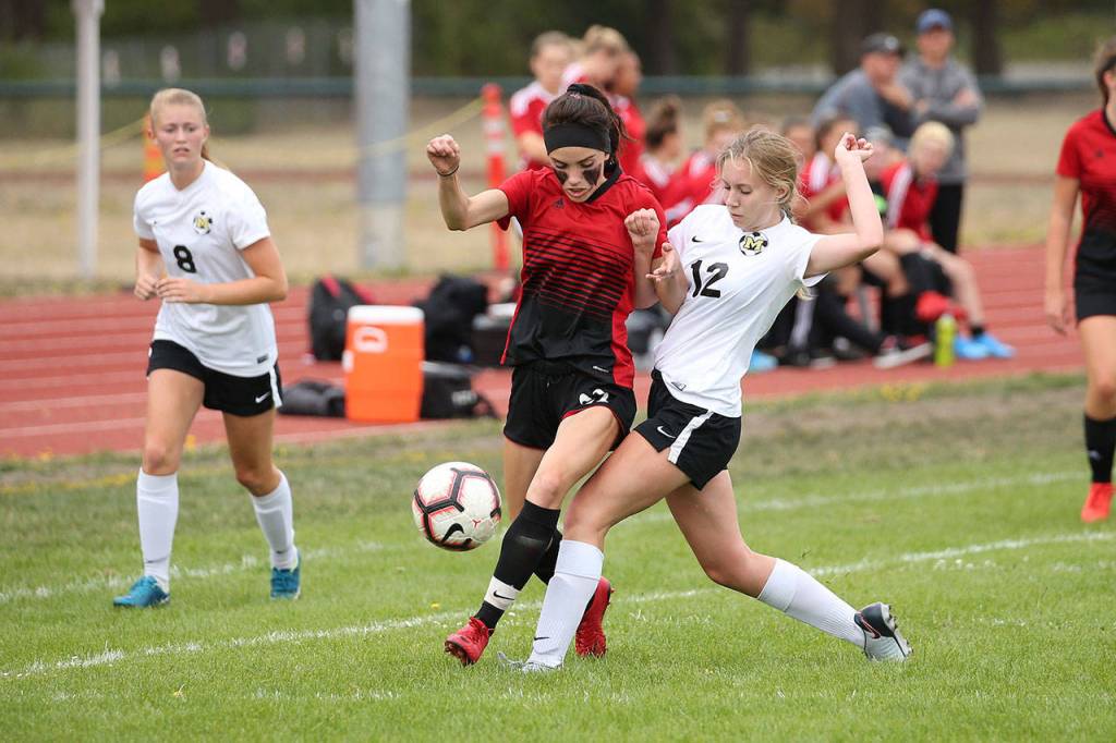 Mallory Kortuem, left, mixes it up with a Meridian player.(Photo by John Fisken)