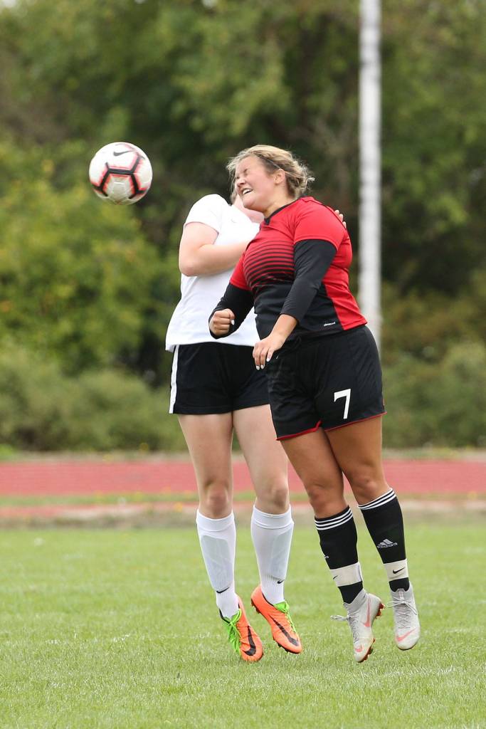 Genna Wright, right, heads the ball for the Wolves.(Photo by John Fisken)