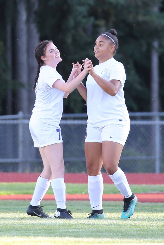Gracie Hiteshew, left, and Tiana Jackson celebrate an Oak Harbor goal.(Photo by John Fisken)