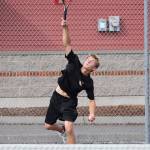 Drake Borden fires a serve in first singles. (Photo by John Fisken)