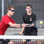 Zach Ginnings, left, returns a shot in his win in second doubles with partner Andrew Aparicio.(Photo by John Fisken)