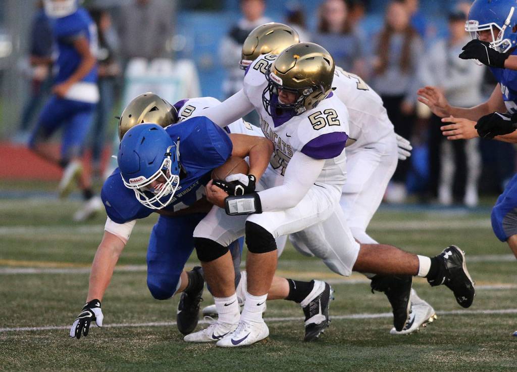 Michael Gomez (52) helps bring down Sedro-Woolleys Dylan Tacker.(Photo by John Fisken)