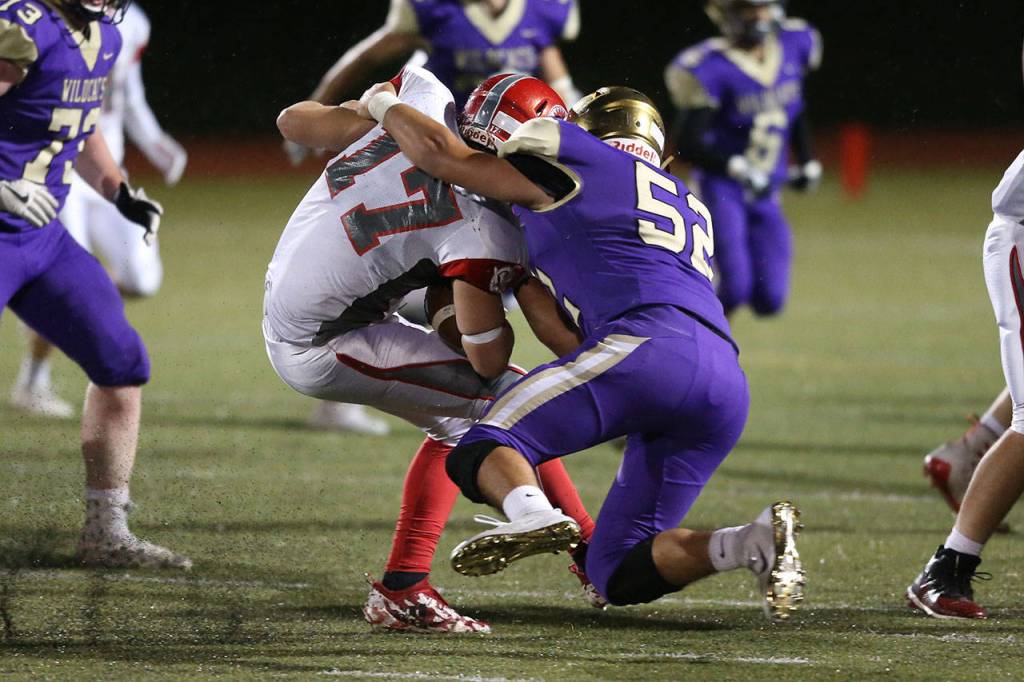 Michael Gomez (52) wrestles Caden Lukehart to the ground.(Photo by John Fisken)