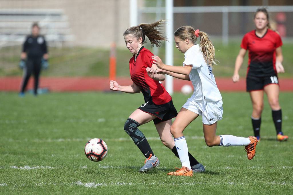 Sophia Martin, left, wins the race to the ball.(Photo by John Fisken)
