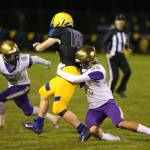 Oak Harbors Aaron Linden tackles Ryan Pelton (18) as Landon Cantrell (4) closes in.(Photo by John Fisken)