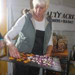 Kim Gruetter from Salty Acre Farm on Whidbey Island shows how to dry edible flowers for blending into natural sea salt made at the farm. Photo by Wendy Leigh / South Whidbey Record