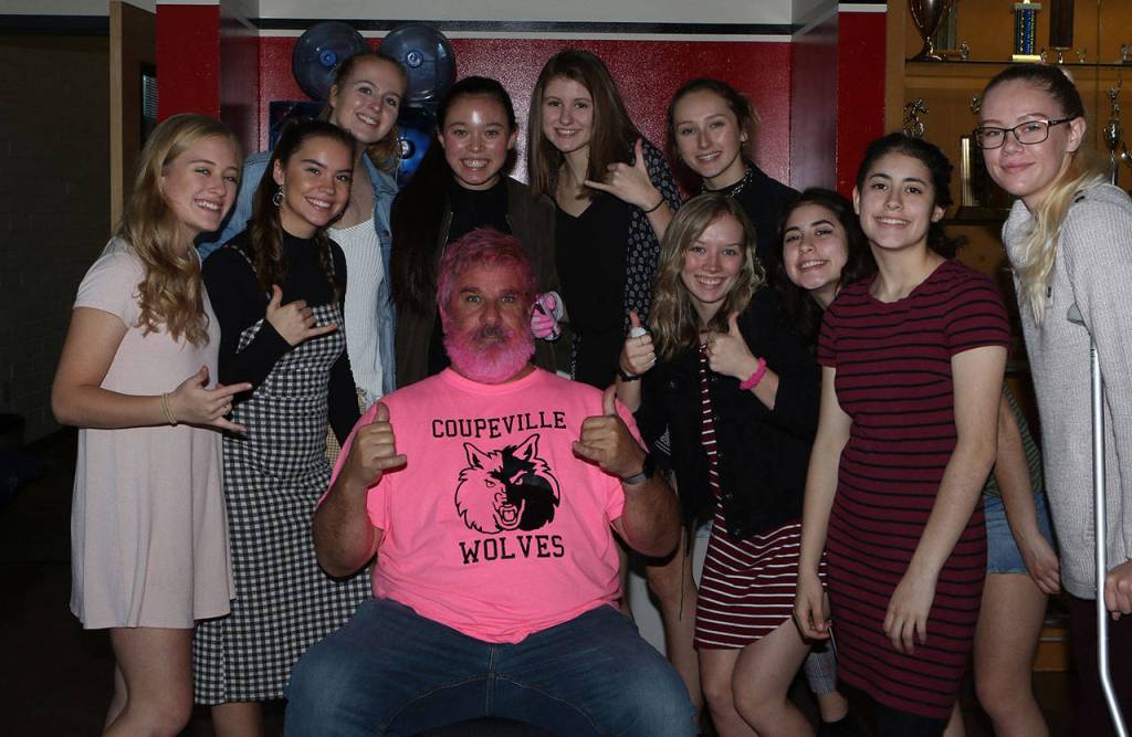 As an annual tradition of Dig Pink Night, the Coupeville volleyball team sprays John Fiskens hair and beard pink and then gives him a trim. Fisken lost his mother and sister to cancer and lends his help to raise awareness for the Wolves cause. (Photo by Lisa Toomey)