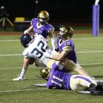 Oak Harbors Luke Golden (11) and Gabriel Daggett (28) haul down Arlingtons Jaden Roskelley.(Photo by John Fisken)