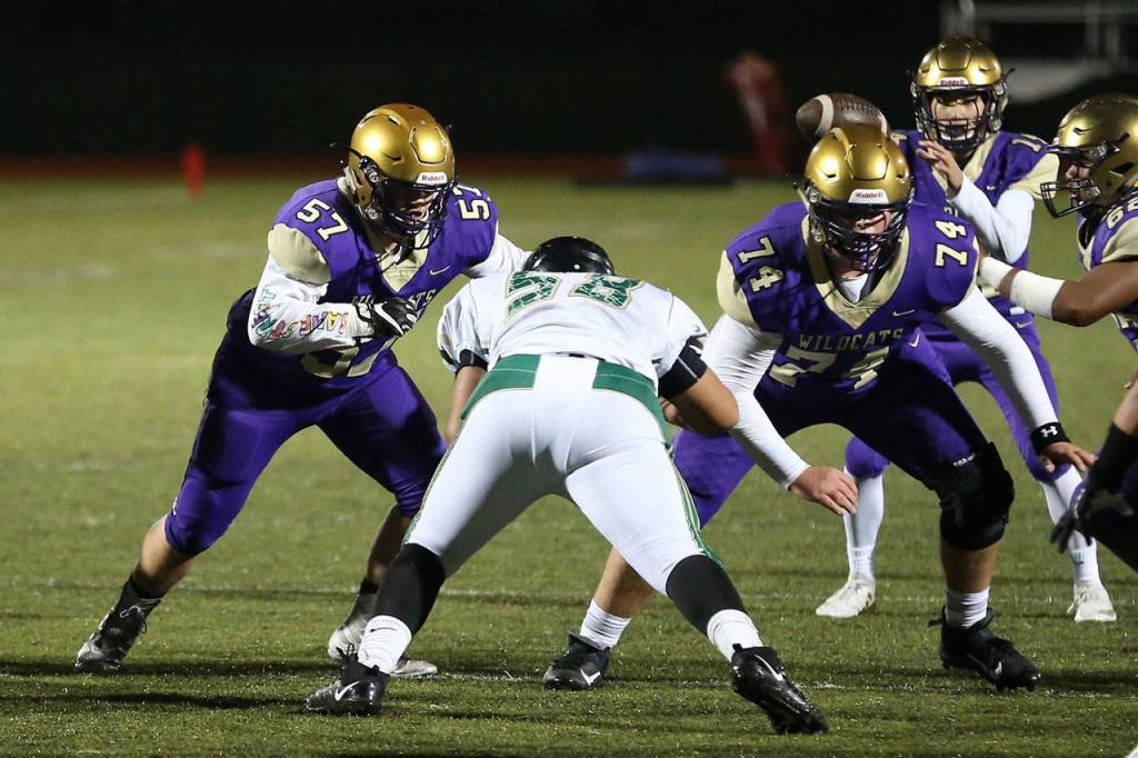 Justin Campbell (57) and John Leete (74) set up to protect quarterback Kaito White.(Photo by John Fisken)