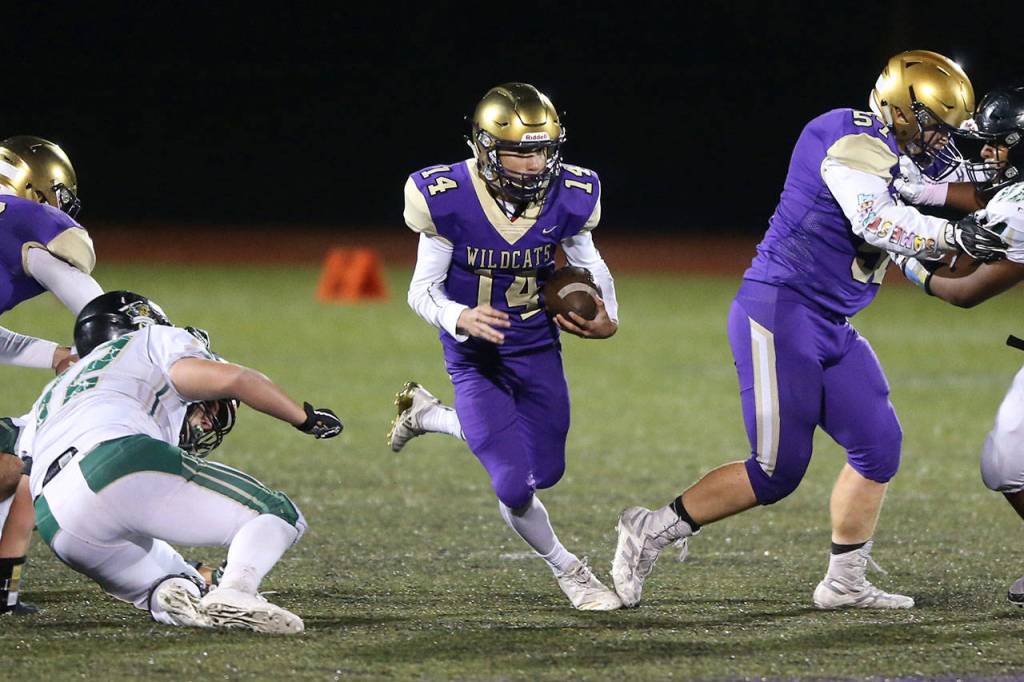 Kaito White (14) scoots through a hole provided by Justin Campbell, right.(Photo by John Fisken)