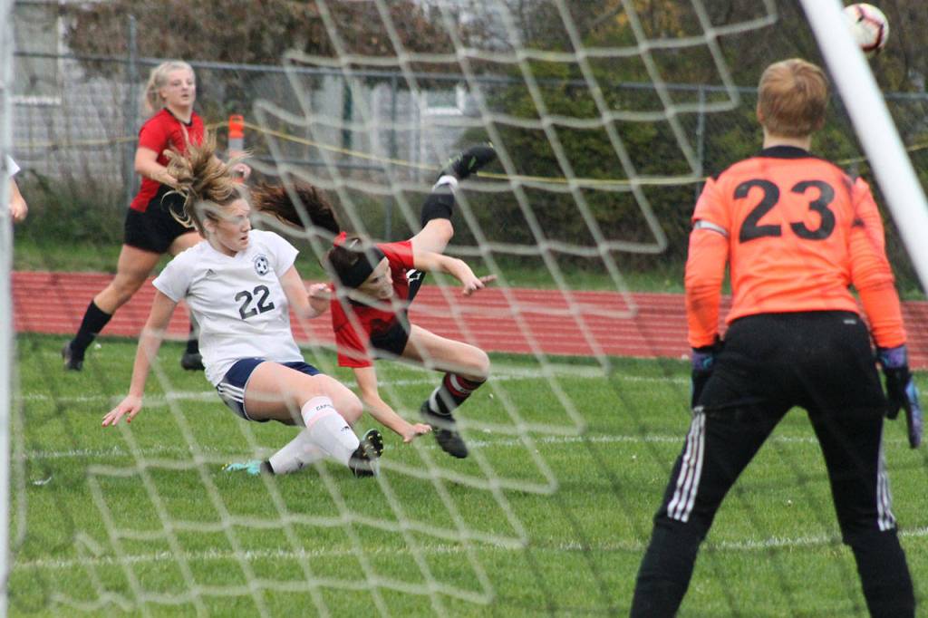 Mallory Kortuem, center, is upended by Sultans Kennedy Wolff. No penalty was called on the play.(Photo by Jim Waller/Whidbey News-Times)
