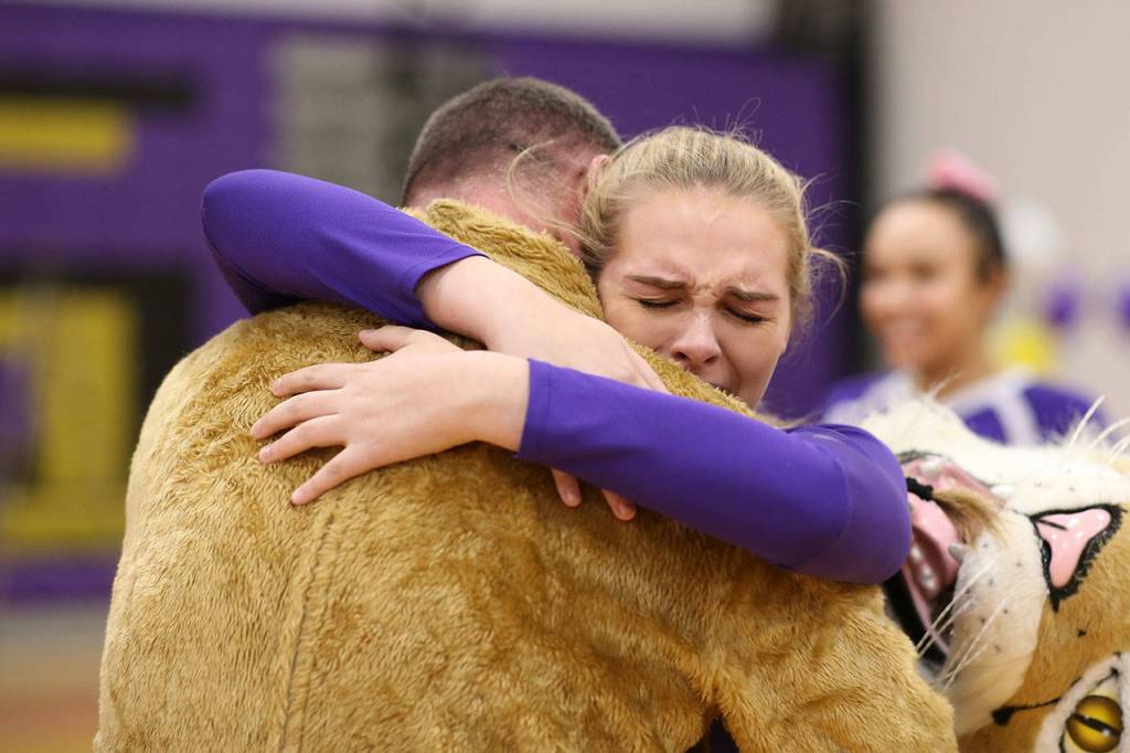 Payton Parks hugs her father, who came home early from deployment. He surprised her by wearing the Wildcats mascot costume.(Photo by John Fisken)