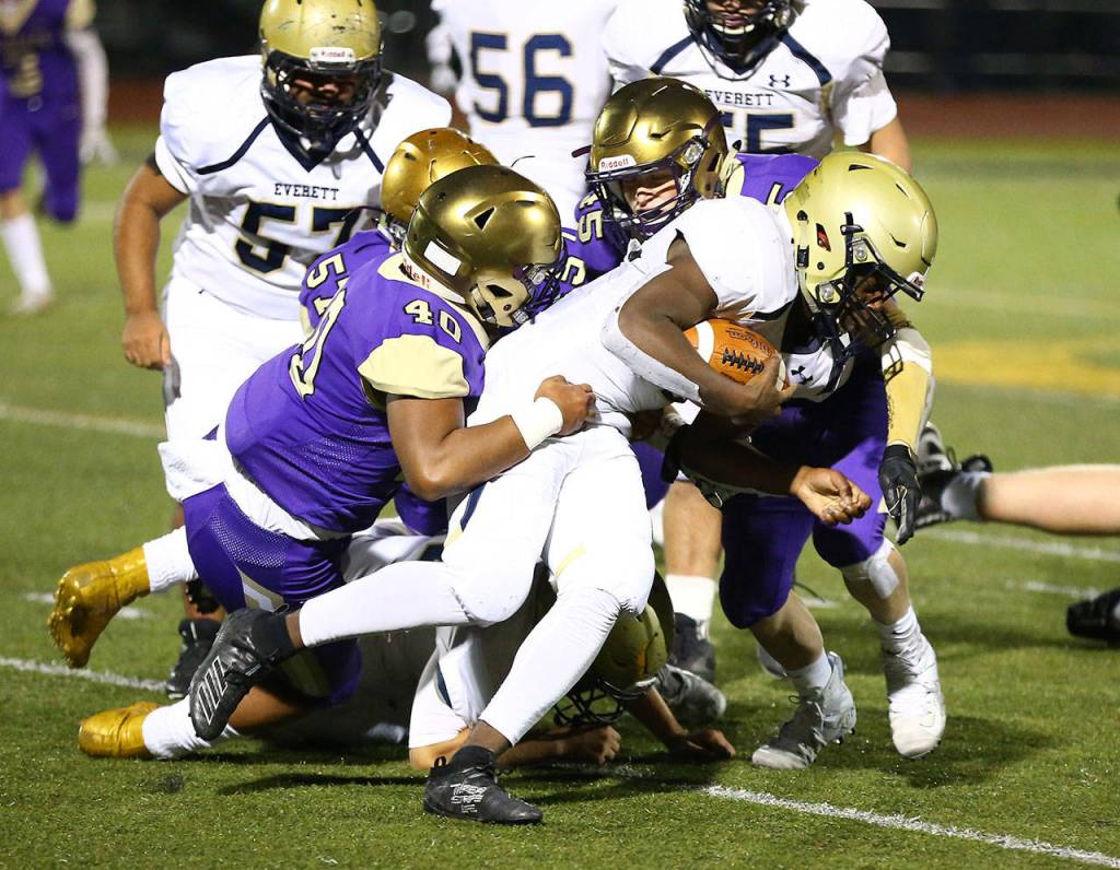 Ezra Decherong (40), Justin Campbell (57) and Caden Leckelt (45) bring down Everetts Jemyre Reed. (Photo by John Fisken)
