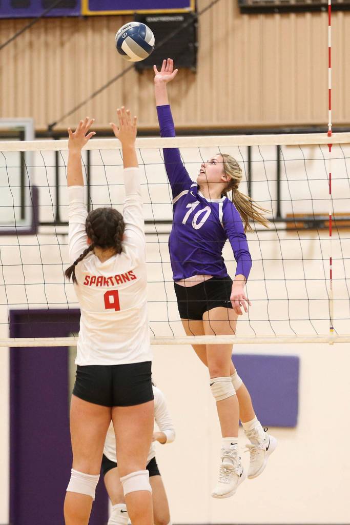 Morgan Pease taps the ball by Stanwood Grace Henken.(Photo by John Fisken)