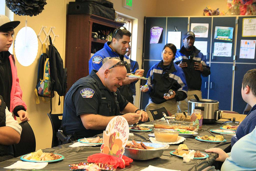 Photo by Laura Guido/Whidbey News-Times                                Officer Matt Krysinski digs into his meal prepared by Oak Harbor exceptional academy students.
