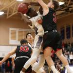 Oak Harbors Kenneth Tofah powers to the hoop against Coupevilles Mason Grove, right.(Photo by John Fisken)