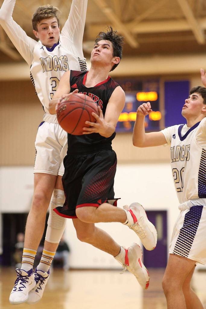 Coupevilles Hawthorne Wolfe splits the defense of Will Rankin, left, and Gage McLeod, right.(Photo by John Fisken)