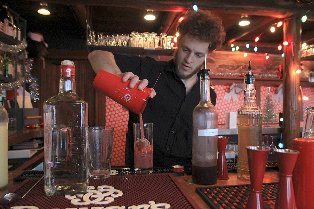 Photo by Laura Guido/Whidbey News-Times                                Captain Whidbey Inn bartender Aaron Bloom mixes a specialty cocktail as part of the Christmas pop-up Miracle. As part of the inns holiday-themed events, community members are invited to help decorate the tree in the lobby, a revival of an old tradition.