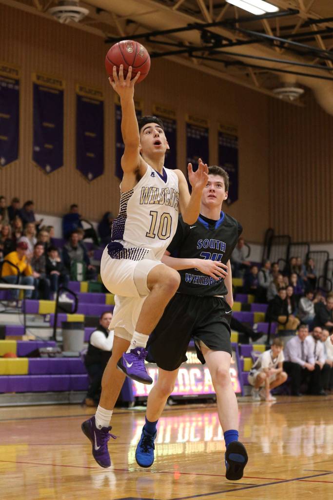 Matt Kelley finishes a fast break ahead of South Whidbeys Sterling Patton.(Photo by John Fisken)