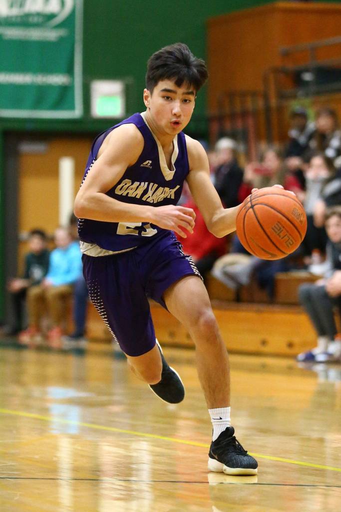 Kaito White hurries the ball up the floor for Oak Harbor.(Photo by John Fisken)