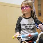 Four-year-old Michaela Reed sails through a hallway at Oak Harbor High School on a bike designed for her by the Wildcat robotics team. File photo by Laura Guido/Whidbey News-Times