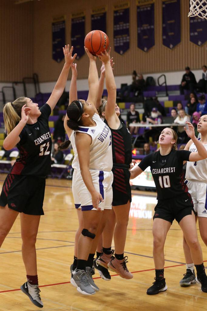 Oak Harbors Tiana Jackson, white uniform, battles for a rebound.(Photo by John Fisken)