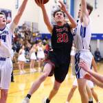 Xavier Murdy (20) splits the defense of South Whidbeys Sterling Patton, left, and Carson Wrightson.(Photo by John Fisken)