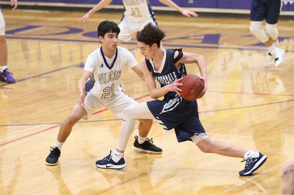 Kaito White, left, puts the clamps on a Meadowdale offensive player.(Photo by John Fisken)