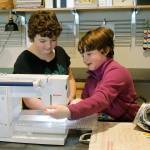 Bella Bond, left, and Arya Bochantin, right, work on the sewing machine together.