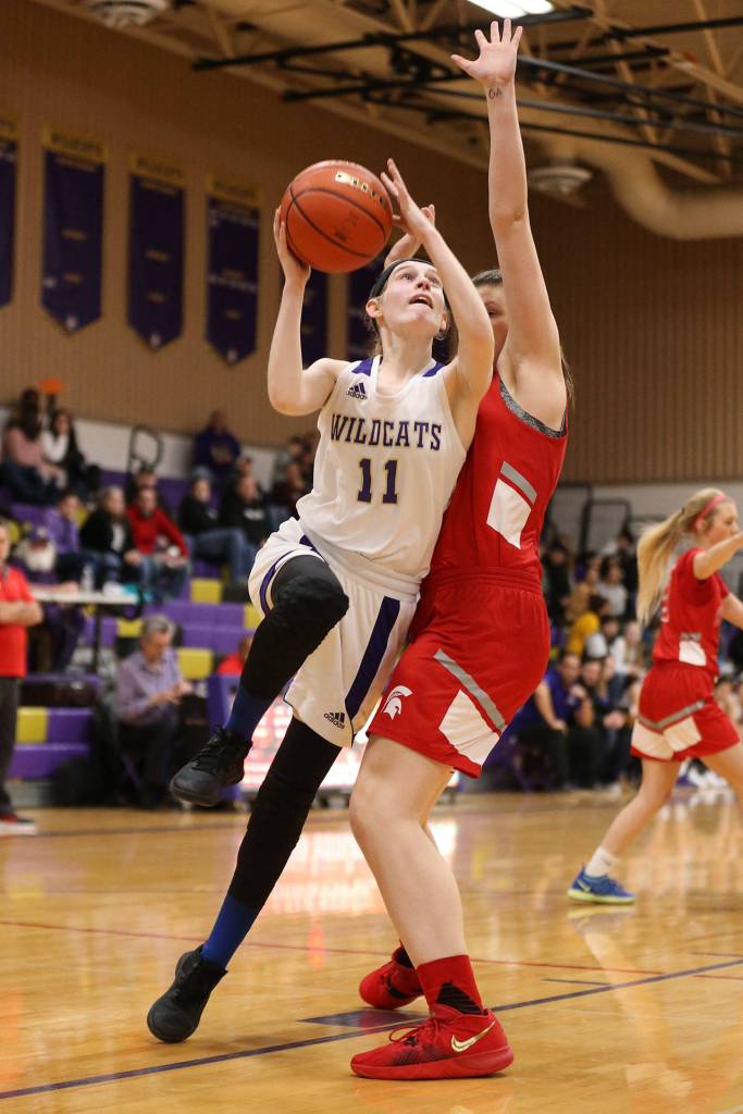 Olivia Waite (11) glides by the defense of Stanwoods Viv Berrett.(Photo by John Fisken)