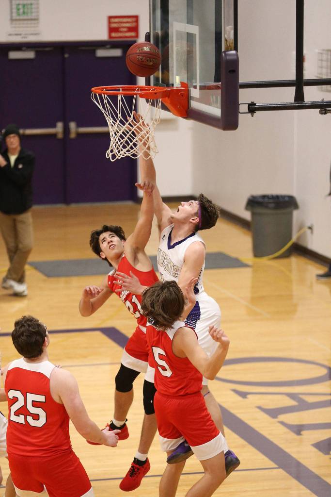 Oak Harbors Mason Myers shoots a reverse layup over Marysville-Pilchucks Dillon Kuk.(Photo by John Fisken)