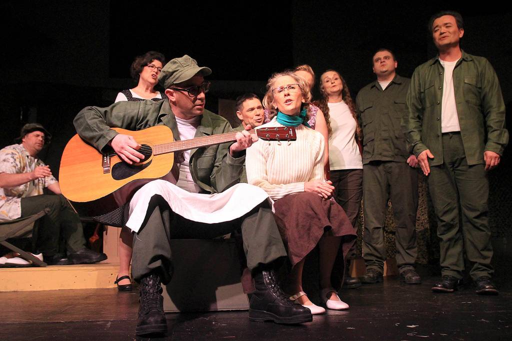 Pvt. Lopez and Lt. Louise Kimble, played by Jason Herken and Vicky Canales Riemer, perform a song that will be familiar to fans of the movie or TV show M*A*S*H during Whidbey Playhouses production of the play.