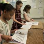 Photo by Brandon Taylor/Whidbey News-Times                                Arianna Watson, 9, Victoria Wiedrich, 9, and Avalee Wormwood, 9, worked on thee solutions section of the book.